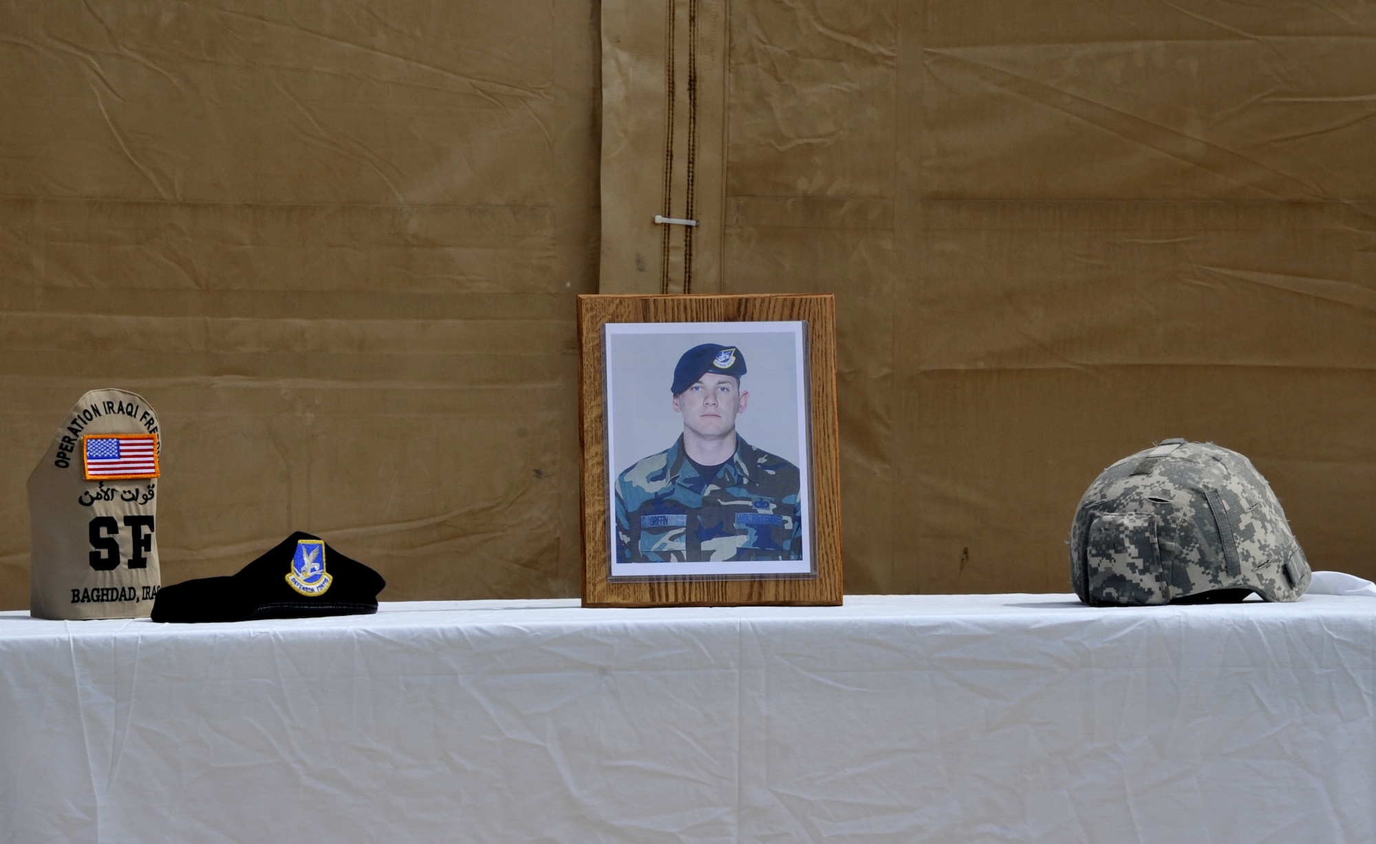 SATHER AIR BASE, Iraq – A table displays a photo of fallen security forces member Staff Sgt. Travis Griffin and items that pertained to his profession during a ceremony here April 3 honoring the lost Airman. During the ceremony Sather Airmen renamed the base fitness center after Sergeant Griffin, who gave his life April 3, 2008, while on patrol in Baghdad, Iraq, when an improvised explosive device impacted his vehicle.  (U.S. Air Force photo by Staff Sgt. Amanda Currier)