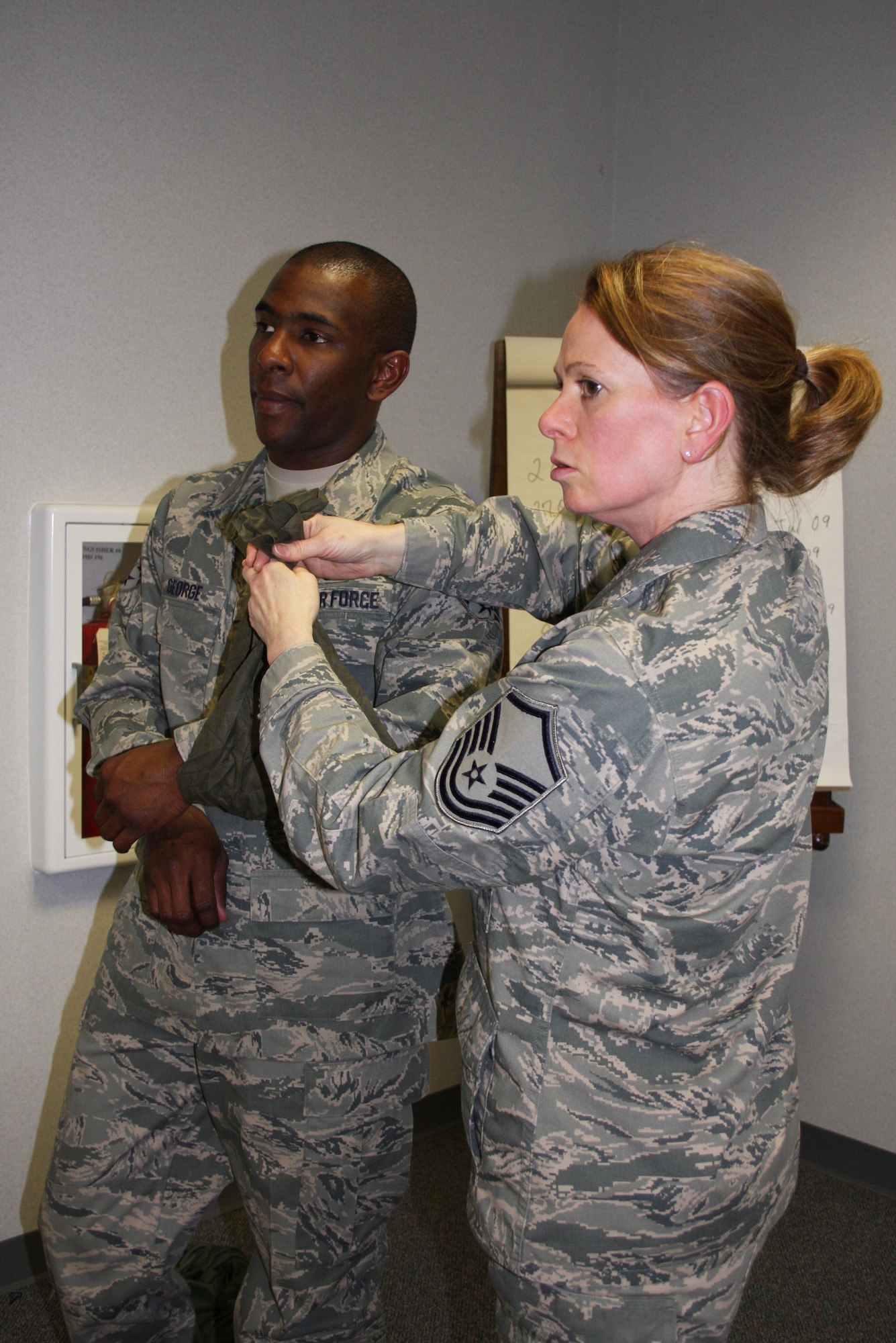 WRIGHT-PATTERSON AFB, Ohio – Master Sgt. Robyn Wilson receives instruction while bandaging Senior Airman Justin George, both from the 87th Aerial Port Squadron, during the hands-on portion of self aid and buddy care training during the April 5th unit training assembly.  In preparation for any future deployment, reservists from the squadron made sure they were current in their training requirements. (Air Force photo/Staff Sgt.  Amanda Duncan) 