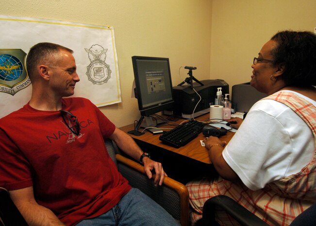 Army Sgt. Maj. Roger Dangerfield provides Tracey Garret with information for the new Defense Biometric Identification System at the visitor's center on Charleston AFB April 6. Any individual issued a Department of Defense identification card must be entered into the DBIDS system before Oct. 5. Sergeant Dangerfield is with the 218th Maneuver Enhancement Brigade and Ms. Garret is a security clerk with the 437th Security Forces Squadron. (U.S. Air Force photo/Senior Airman Timothy Taylor)