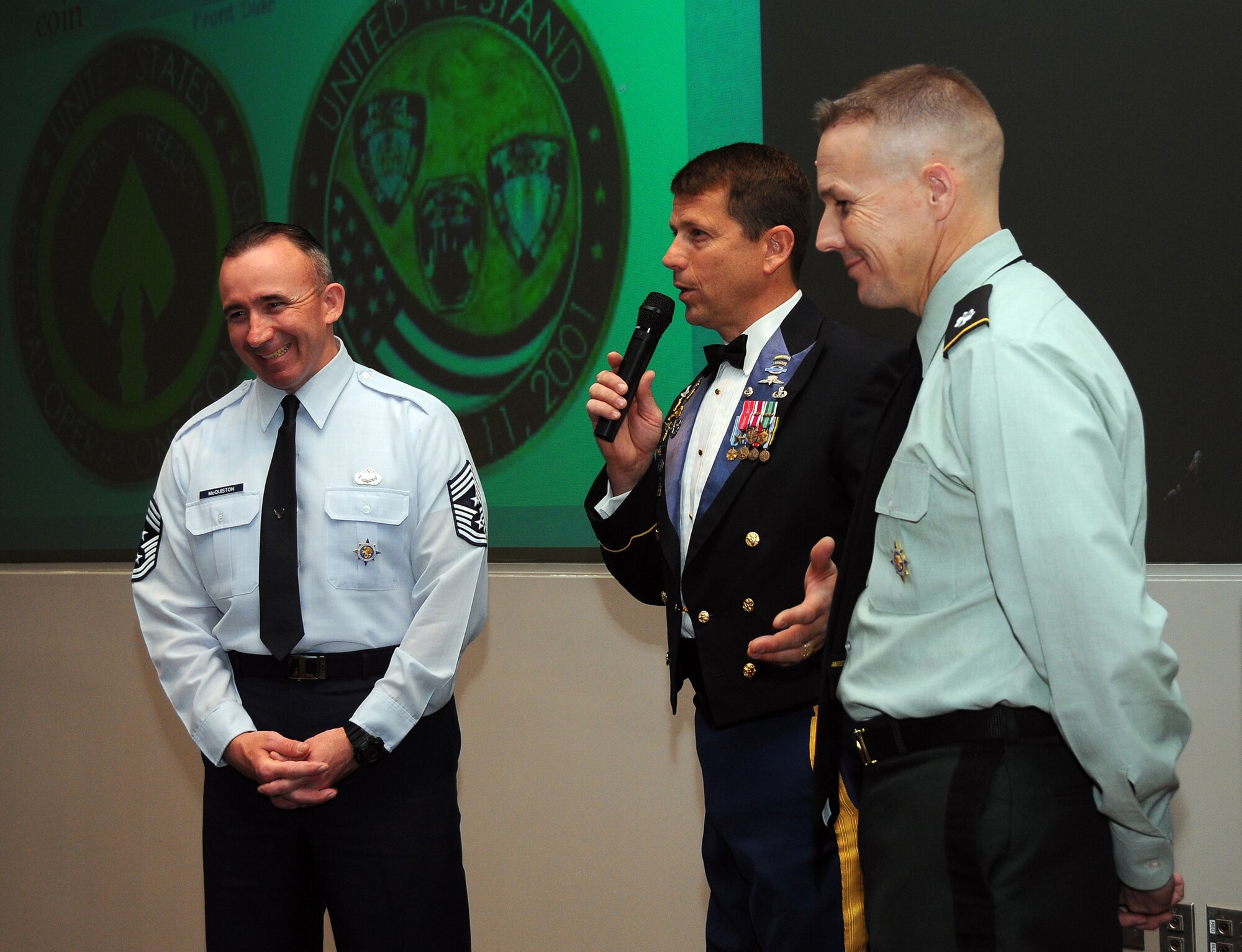 SCOTT AIR FORCE BASE, Ill. --Sgt. 1st Class, retired, Dana Bowman, center, shares a laugh with Chief Master Sgt. Kenneth McQuiston, USTRANSCOM senior enlisted leader, and Lt. Col. Robert Durbin, after he addressed a group of USTRANSCOM workers April 6, in the command's Seay Auditorium.  During his hour-long presentation, Bowman received numerous standing ovations as he spoke about overcoming disabilities and never giving up.  (Photo courtesy Bob Fehringer) 