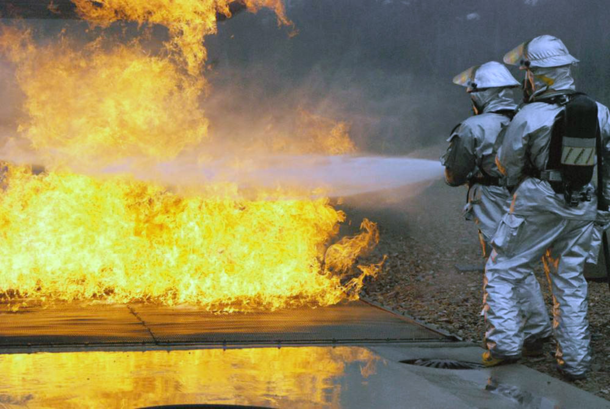 Airmen extinguish a flare up below an aircraft's wing during a training exercise at the Woensdrecht Firefighting Training Facility in the Netherlands. Members of the 309th Airlift Squadron from Chievres Air Base, Belgium, trained on firefighting techniques at the simulator. (U.S. Air Force photo) 
