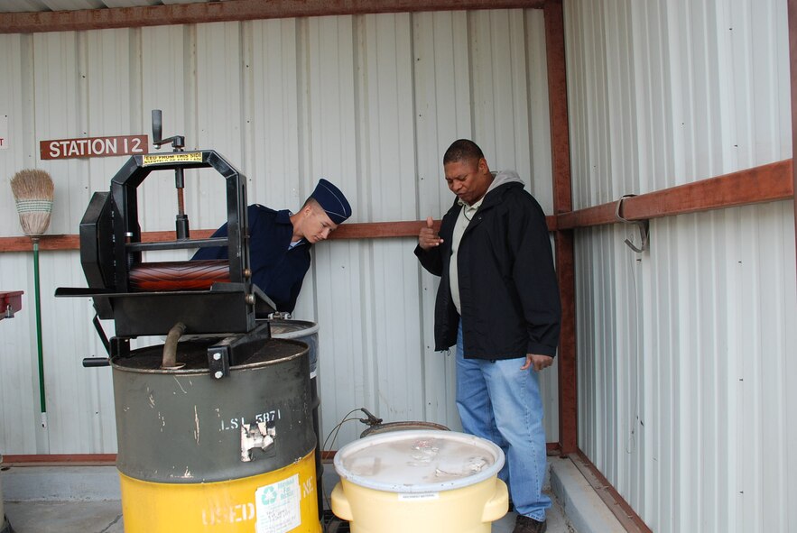 Second Lt. Jason Pettengill, a transition student assigned to the 47th Installation Support Squadron (Provisional), and Mr. Don Murray, 47th ISS (P) installation hazardous waste manager, inspect a wringer system that is used to take solvents out of rags so the rags can be reused. Hazardous waste is one of the guidelines to be inspected by the Air Education and Training Command Environmental Safety and Occupational Health Compliance Assessment Management Program external audit April 20 through 24. (U.S. Air Force photo by Ron Scharven)