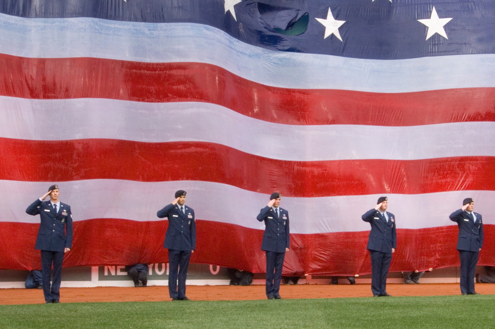 HANSCOM AIR FORCE BASE, Mass. –66th Security Forces Squadron Airmen render salutes during the playing of the National Anthem at pre-game festivities for the Boston Red Sox season opener at Fenway Park on April 7. (U.S. Air Force photo by Mark Wyatt) 