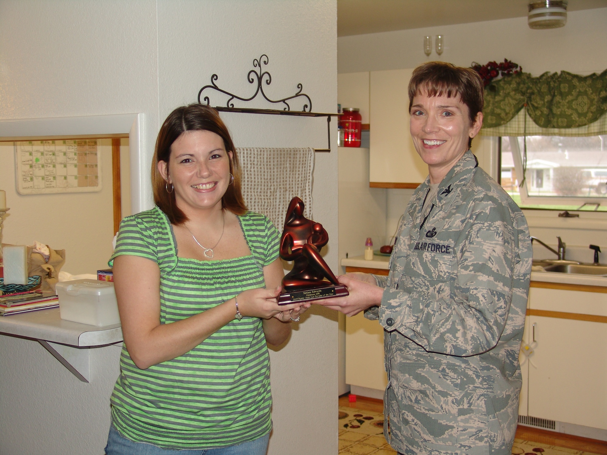 WHITEMAN AIR FORCE BASE, Mo. -- Melissa Edwards (left), wife of Senior Airman Steven Edwards, 509 Maintenance Squadron, accepts the 2009 Whiteman Family Child Care Provider of the Year award from Col. Patricia McGinnis, 509th Mission Support Group commander.  Mrs. Edwards was nominated by parents and other Family Child Care providers.  Using specific criteria, the Family Child Care panel selects the provider most deserving. Congratulations! (US Air Force Photo/Kerri Lancaster)