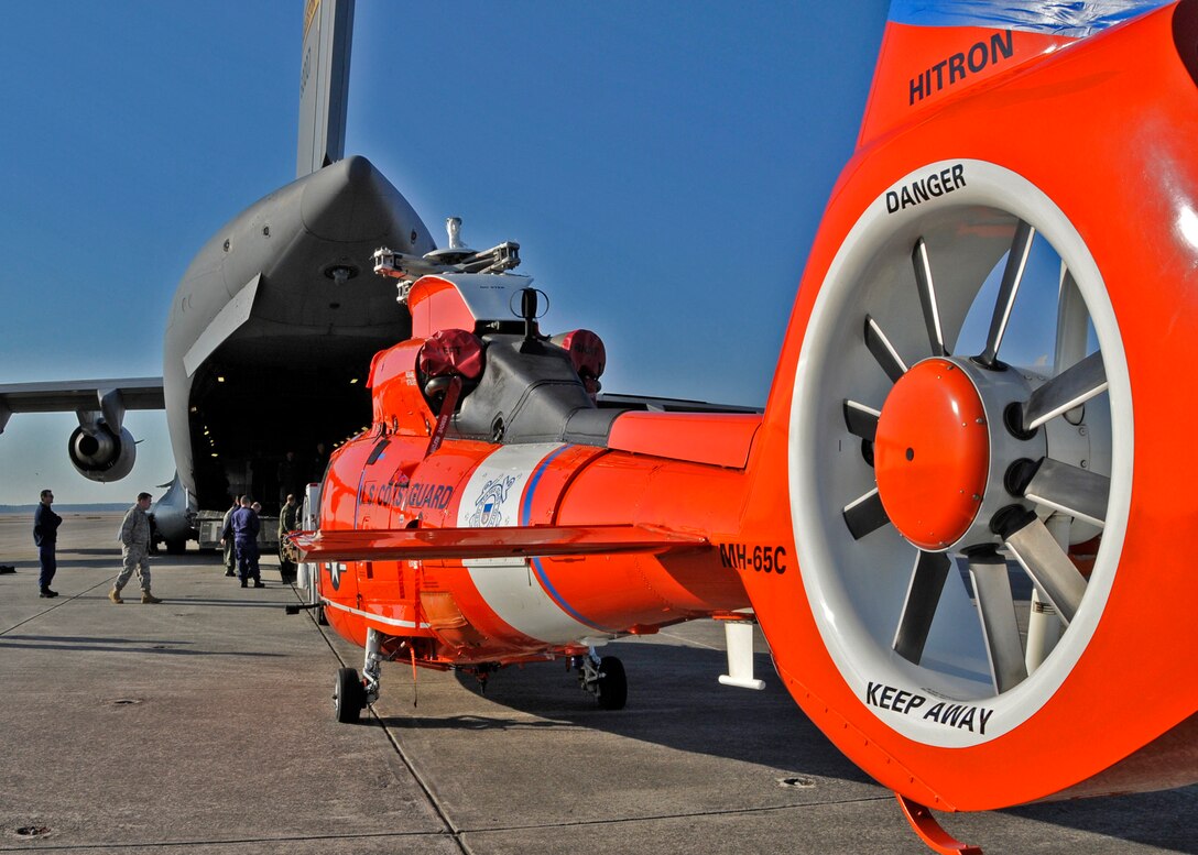 An aircrew from the 315th Airlift Wing, Charleston AFB, S.C. prepares to load a Coast Guard helicopter aboard a C-17 Globemaster III.  The helicopter is on its way to Central America. (Air Force photo/Captain Chett Collier)