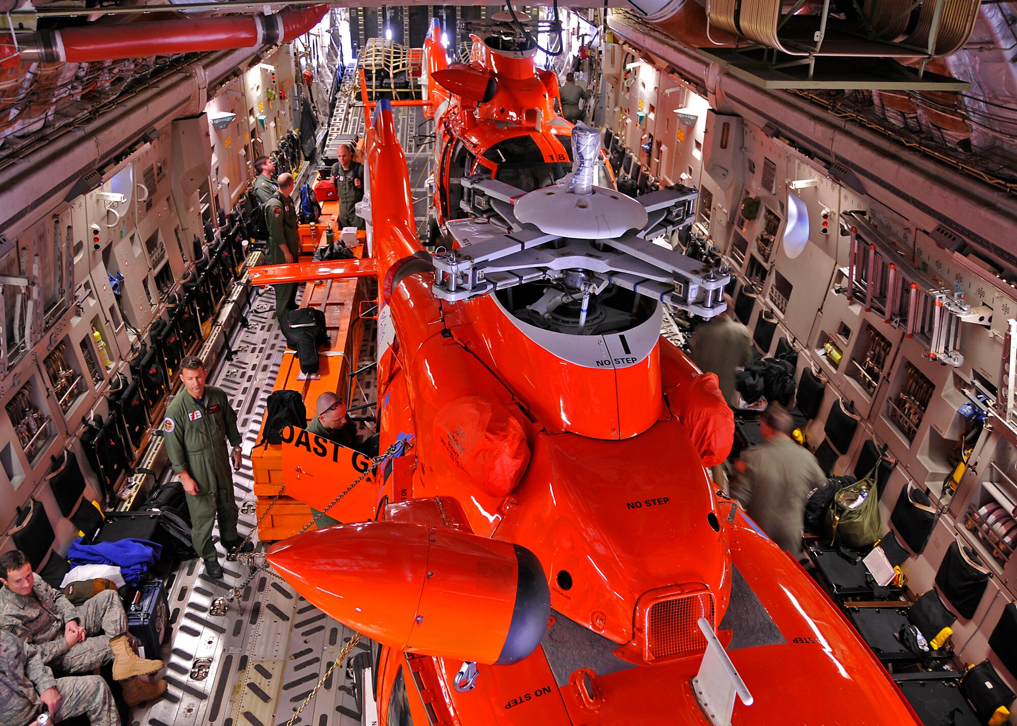 A C-17 Globemaster III aircrew from the 315th Airlift Wing, Charleston AFB, S.C. loads two Coast Guard helicopters in preparation for flight.  The helicopters are being delivered to Central America. (Air Force photo/Captain Chett Collier)