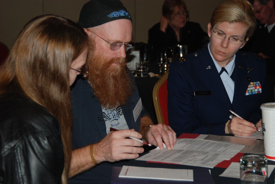 James P. McGarvey and his wife, Alice McGarvey, left, and Air Force Capt. Camille Carson, a research analyst with the Defense Prisoner of War/Missing Personnel Office, look over reports of how McGarvey's father, former Marine Corps pilot Lt. Col. James M. McGarvey, went missing during a bombing run off the northeastern coast of Vietnam, April 17, 1967. The McGarveys attended the office’s family outreach meeting in Bethesda, Md., March 28, 2009. U.S. Army photo by Staff Sgt. Matthew Chlosta
