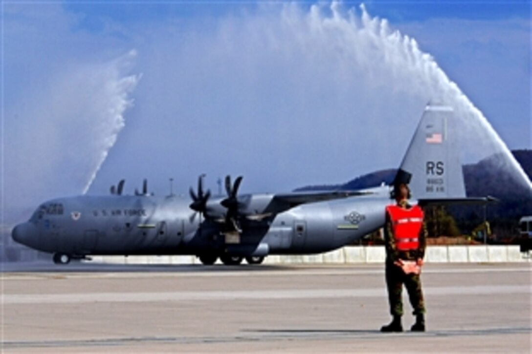 The first C-130J Super Hercules to be assigned to Ramstein Air Base, Germany, taxies under pressured water from two base fire trucks during an arrival ceremony, April 7, 2009. This aircraft is the first of 14 J-models scheduled to arrive over the next 12 months to replace the older E-model Hercules.