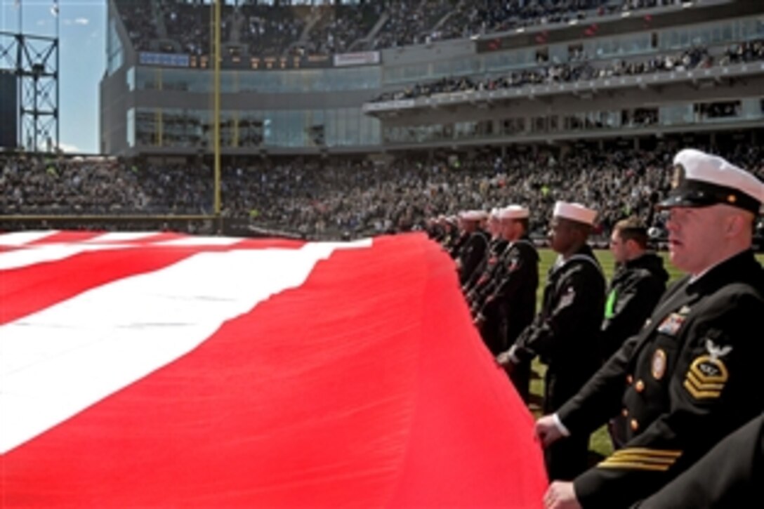 More than 120 U.S. Navy sailors assigned to commands on Naval Station Great Lakes participate in opening ceremonies for the Chicago White Sox at U.S. Cellular Field, Chicago, where they unfurled a 300 by 150 foot flag during the national anthem, April 7, 2009.