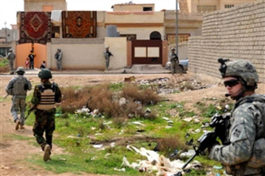 U.S. and Iraqi army soldiers patrol along streets searching for a weapons cache in Mosul, Iraq, April 5, 2009. The U.S. soldiers are assigned to Company C, 1st Battalion, 67th Armored Regiment.