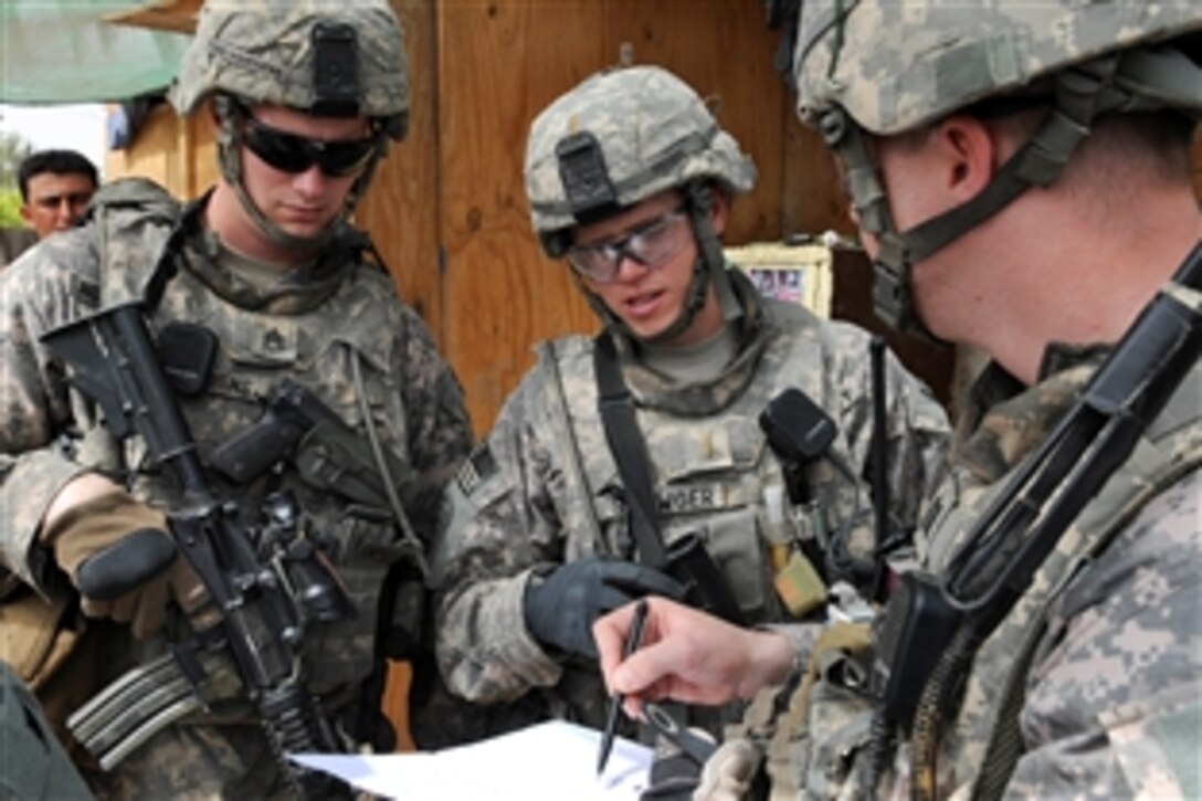 U.S. Army Staff Sgt. Perry Houchens, left, and 2nd Lt. Richard Shawger, center, listen to Army Cpt. Brian England, right, discuss checkpoint operations near Joint Security Station Loyalty in eastern Baghdad, Iraq, April 7th, 2009. Houchens, Shawger and England are assigned to the  82nd Airborne Division's Brigade Special Troops Battalion, 3rd Brigade Combat Team.