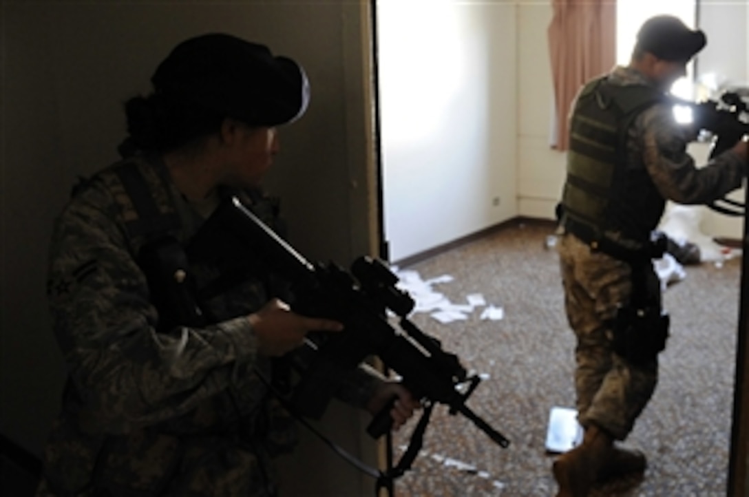U.S. Air Force Airmen 1st Class Elizabeth Bolanos (left) and Steven Fischer, police officers with the 28th Security Forces Squadron, perform a dynamic entry during training at Ellsworth Air Force Base, S.D., on March 25, 2009.  Dynamic entries are used for high-risk incidents that could require the use of armed force.  