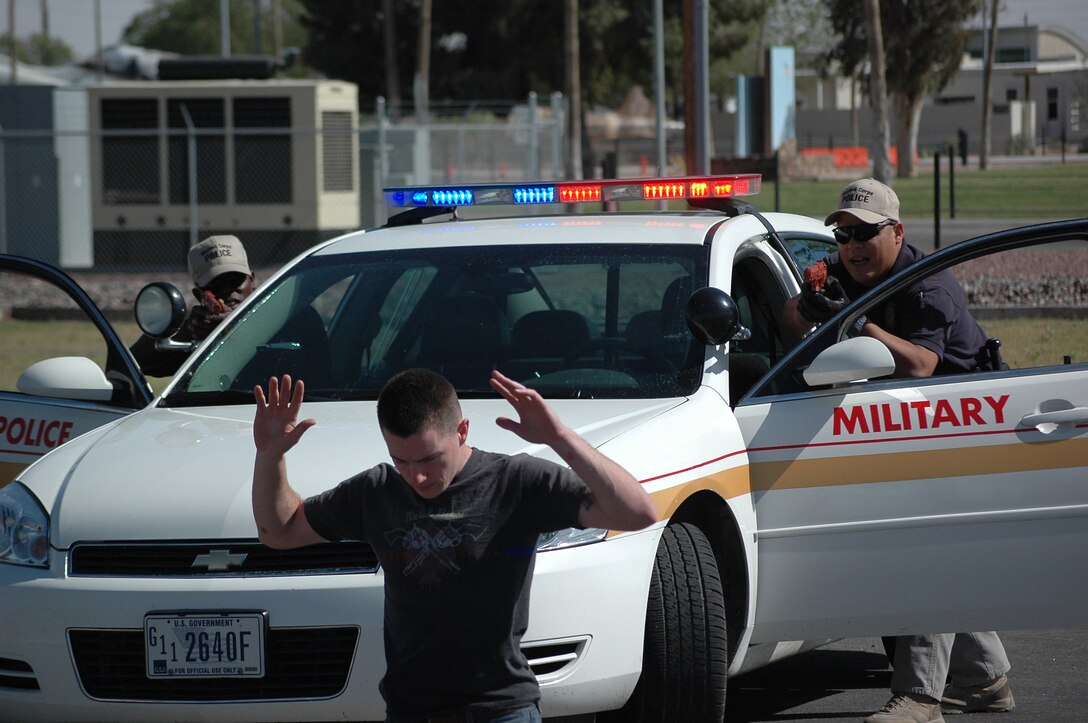 Jazz Sadik, left, and Jose Arguilles, Marine Corps Air Station Yuma, Ariz., Marine Corps Police Academy cadets, apprehend Pfc. Paul Henry during a known-risk traffic stop exercise in a parking lot on station April 8, 2009. Arguelles and Sadik are part of the last class of cadets to be trained in Yuma. Future cadets will be sent to the Marine Corps Air Station Miramar, Calif., academy, along with other West Coast installation cadets.