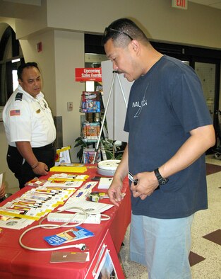 ANDERSEN AIR FORCE BASE, Guam -- Senior Chief Petty Officer Dennis Manacup, USS Harpers Ferry food service officer, speaks with Bryan Hanohano, , Andersen Fire Department inspector, about electrical fire safety at the Andersen commissary April 7. From April 6 through April 10, Team Andersen observed an out-of-cycle fire prevention week in efforts from April 6 to April 10 to review electrical safety specifically due to recent safety concerns throughout Pacific Air Forces.  (U.S. Air Force photo by Airman Carissa Wolff)