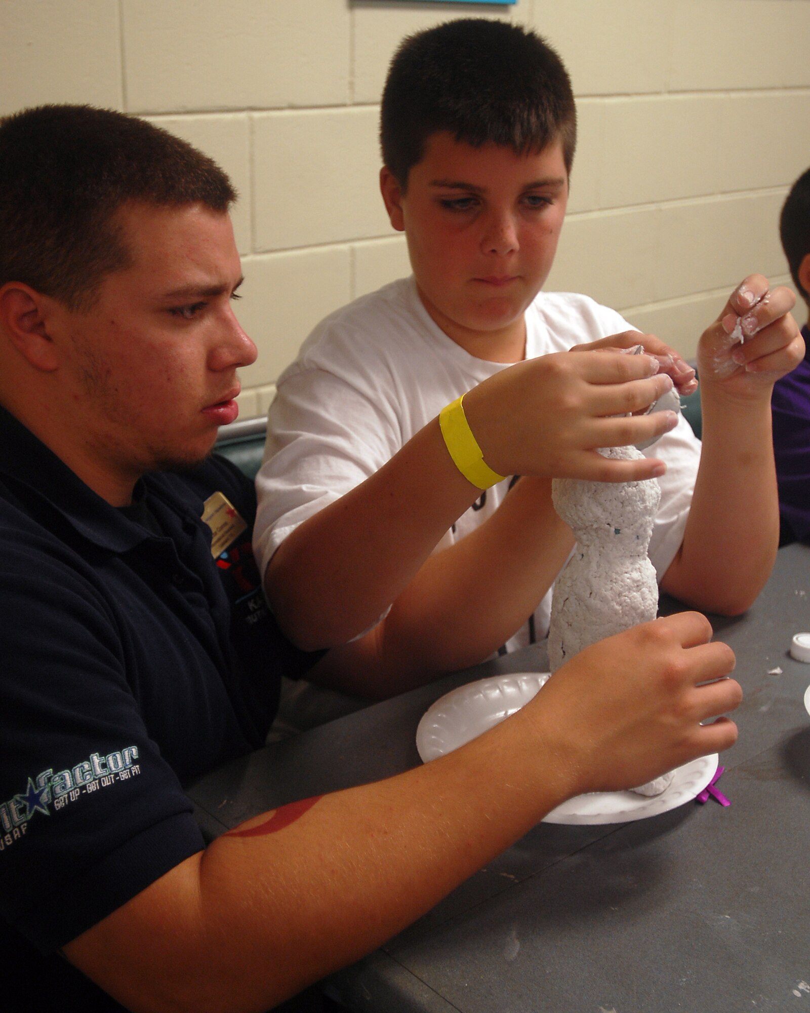 Jesse Smith (right), son of Jen and Tech. Sgt. Josh Smith, 31st Rescue Squadron, gets help with his paper mache Easter bunny from Victor Correa, 18th Force Support Squadron recreational assistant. The Kadena Youth Center and School Age Program offer a variety of activities for youths during spring break.
(U.S. Air Force official photo/Staff Sgt. Nestor Cruz)