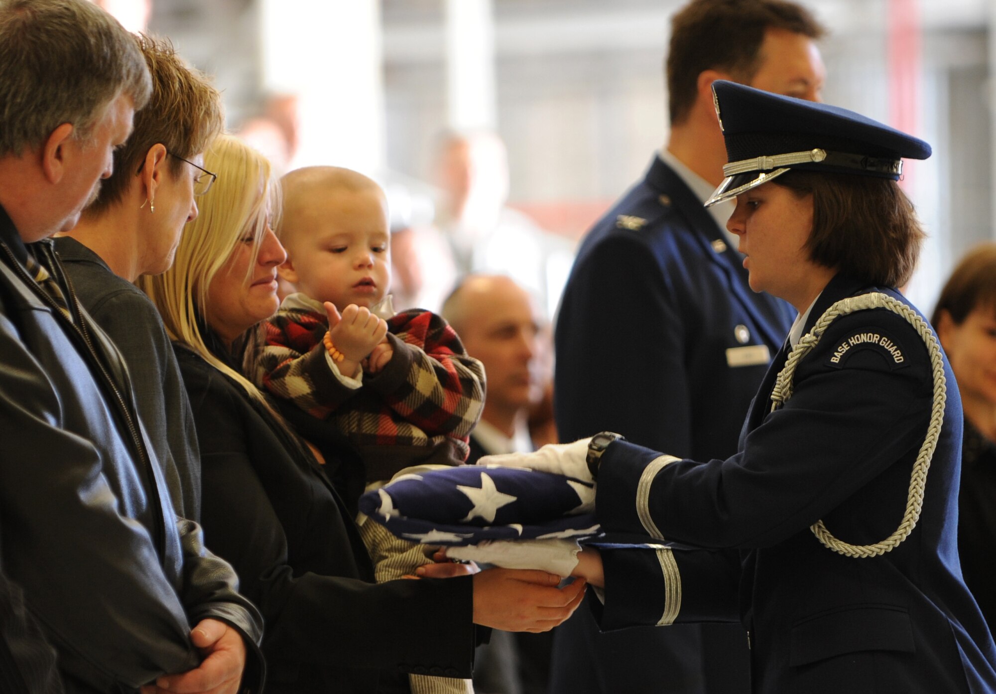 MOUNTAIN HOME AIR FORCE BASE, Idaho -- Honor Guard member Capt. Rebekah Mooney presents a flag to Kendra Stachum, wife of Tech. Sgt. Donald P. Stachum, at a memorial service April 9. Sergeant Stachum was a member of the 366th Security Forces Squadron who passed away April 5. (U.S. Air Force photo/ Airman 1st Class Renishia Richardson)