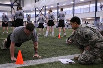 Army Sergeant Neirasha Tucker keeps count of Specialist Alex Hagy's push-ups at Baker Field House April 9, 2009, Eielson Air Force Base, Alaska. Soldiers from Fort Wainwright frequently use Eielson's fitness center during the winter months for its large indoor track and field.  Personnel from Eielson and Wainwright team up often due to the close proximity of the two military installations and their strong rapport. (U.S. Air Force photo/Airman 1st Class Laura Max) 