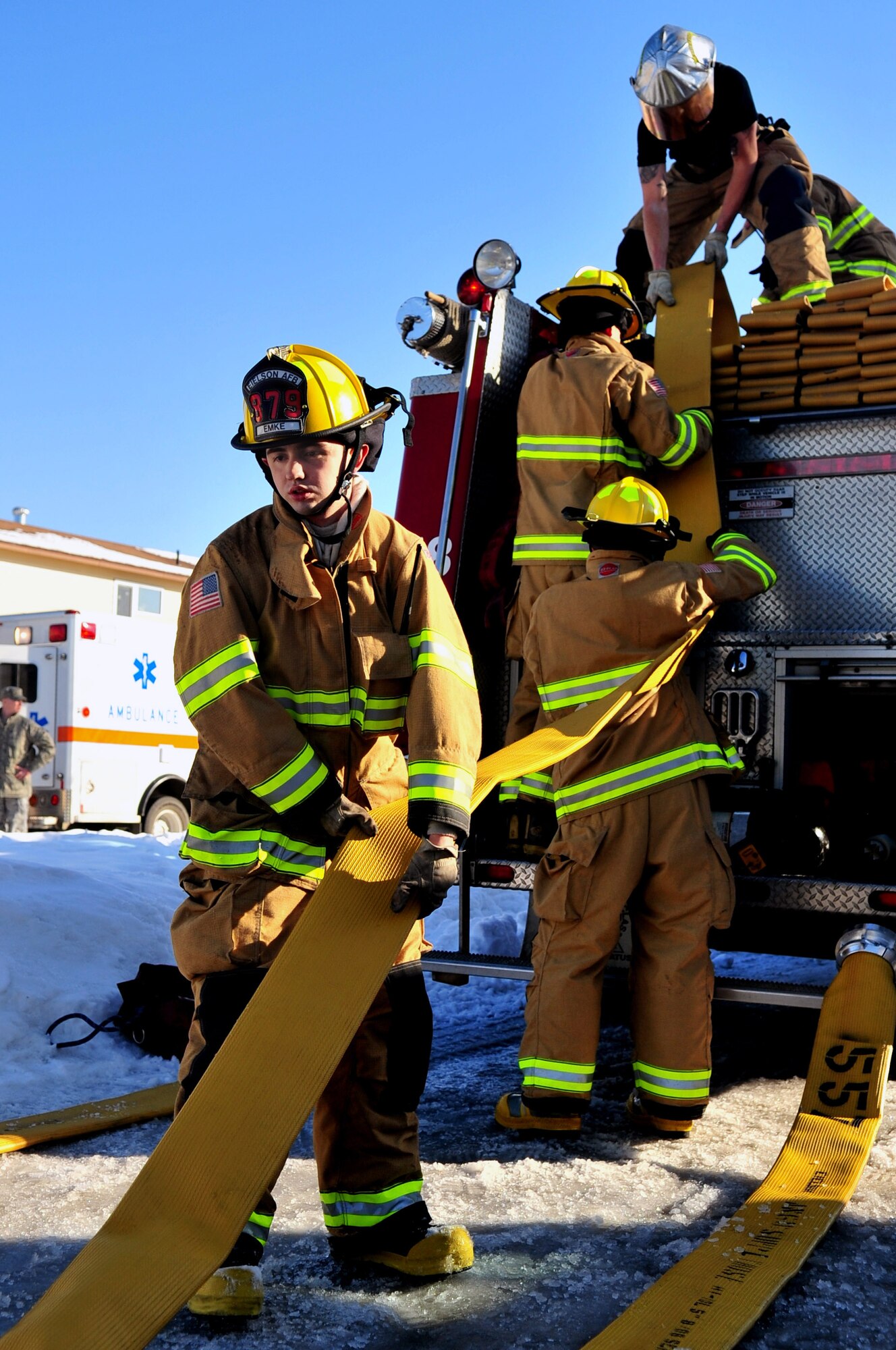 Airmen from the base fire department roll up fire hoses after responding to a fire at an on-base residence April 6 at Eielson Air Force Base, Alaska. Firefighters responded to the scene within five minutes and helped mitigate property damage. (U.S. Air Force photo/Senior Airman Christopher Boitz) 
