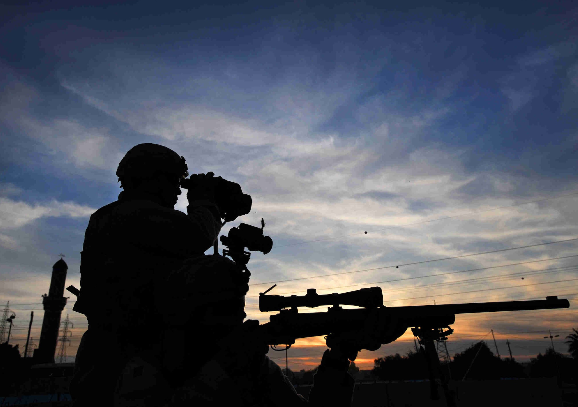 Airmen sharpshooters scan the horizon for possible threats December 2008 in the Al Doura community of southern Baghdad, Iraq. The Airmen are assigned to a close precision engagement team with the 732nd Expeditionary Security Forces Squadron with the 716th Military Police Battalion. (U.S. Navy photo/Petty Officer 2nd Class Todd Frantom)