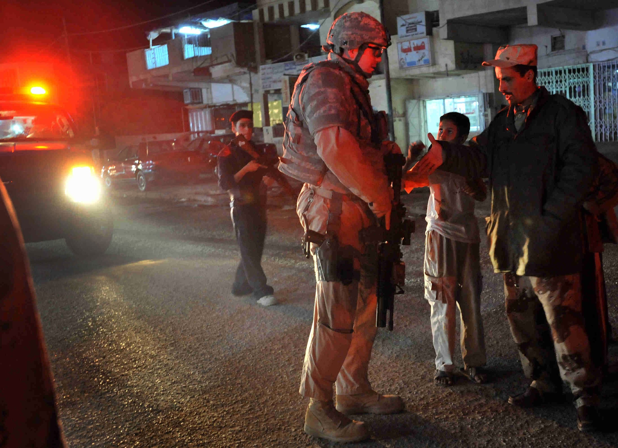 Staff Sgt. Davy Huffman speaks with a Sons Of Iraq soldier during a night-time patrol along the 60th Street Market area meeting Iraqi civilians, handing out toys to the children and speaking with local business owners November 2008 in the Al Doura community located in southern Baghdad, Iraq. The Airman is assigned to Detachment 3, 732nd Expeditionary Security Forces Squadron with the 716th Military Police Battalion. (U.S. Navy photo/Petty Officer 2nd Class Todd Frantom) 