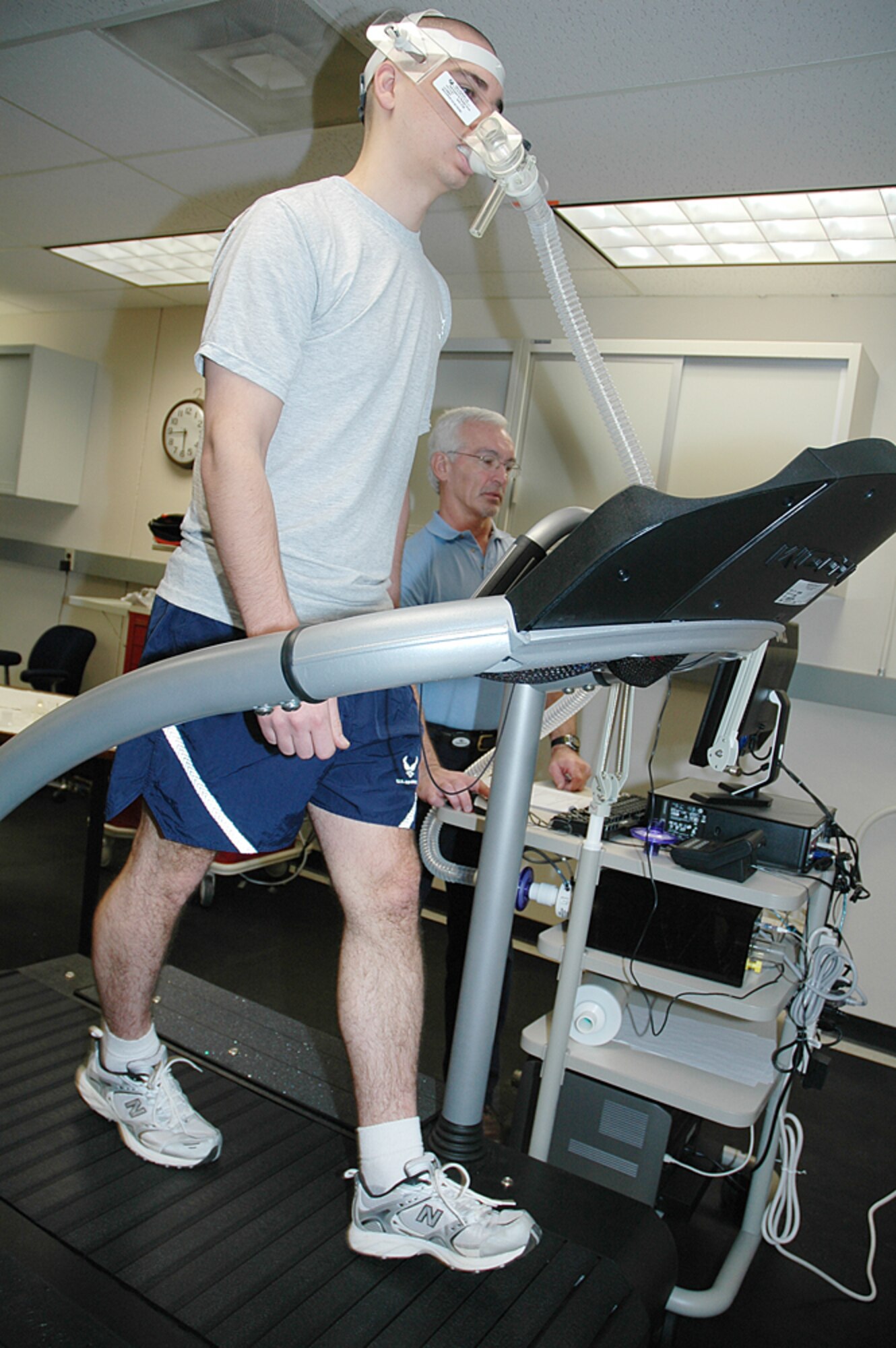 Dr. Ed Eveland (right, background), research physiologist with the 711th Human Performance Wing, observes Lt. Brad Kozenko on a specialized treadmill designed for research applications. Lt. Kozenko is attached to instruments that measure a test subject’s aerobic capacity. The Air Force partnered with Wright State University and the University of Dayton to study nontraditional training methods for improving warfighter performance. (Photo by Chris Gulliford 711 HPW)