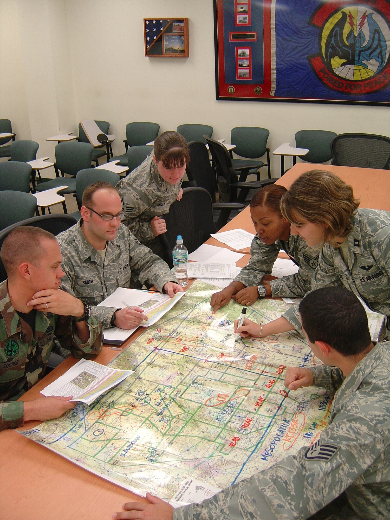 The 728th Air Control Squadron selected Turkey Shoot competition team review a map of the Nevada Test and Training Range, where the simulated war took place during a March exercise. From left to right are Airman 1st Class Robert Sochor, Staff Sgt. Andrew Smith, Senior Airman Lisa Mills, Staff Sgt. LaToya Johnson, Capt. Kisha Balling and Staff Sgt. Anthony Rigazio.