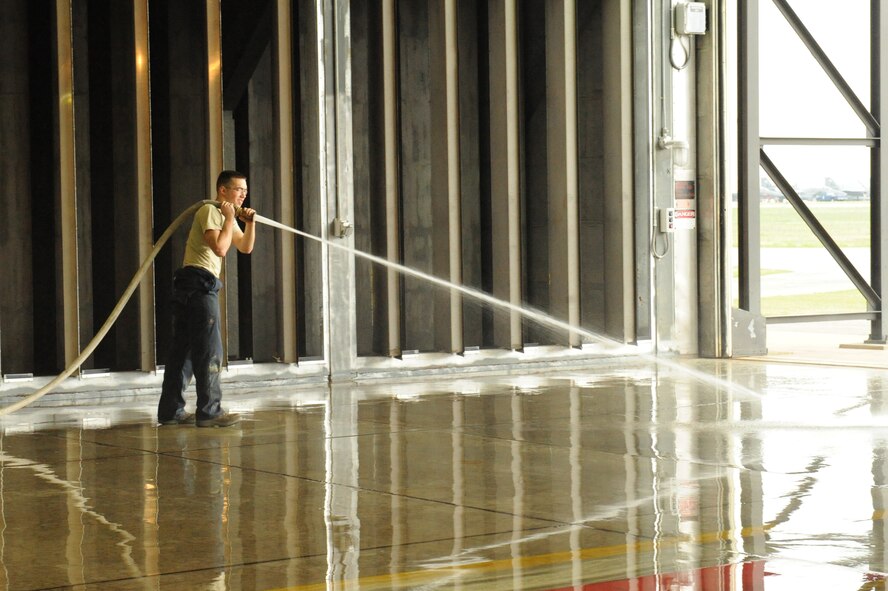 Senior Airman Isaiah Smith, 4th Component Maintenance Squadron, sprays water on the hush house floors to remove loose debris at Seymour Johnson Air Force Base, N.C., April 6, 2009. Before running the engine test Airmen must ensure no debris is present that will damage the engine. (U.S. Air Force photo by Airman 1st Class Whitney S. Lambert) 