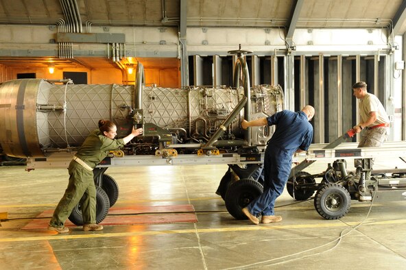 Staff Sgts. Emily Thompson and Robert Stewart, and Tech. Sgt. John Hamrick, 4th Component Maintenance Squadron, transfer a jet engine from a trailer in preparation for testing in the hush house at Seymour Johnson Air Force Base, N.C., April 6, 2009. The trailers are used to lift engines to the proper height for testing. (U.S. Air Force photo by Airman 1st Class Whitney S. Lambert)