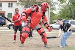Staff Sgt. Samson McFarland (center), 12th Security Forces Squadron, takes a beating from Cameron Jones (left) and Cody Welch during an SF demonstration at Fam-a-ganza at the Randolph Air Force Base Youth Center April 4. More than 100 children participated in Fam-a-ganza, an annual event at Randolph that celebrates the month of the military child. (U.S. Air Force photo by Steve White)