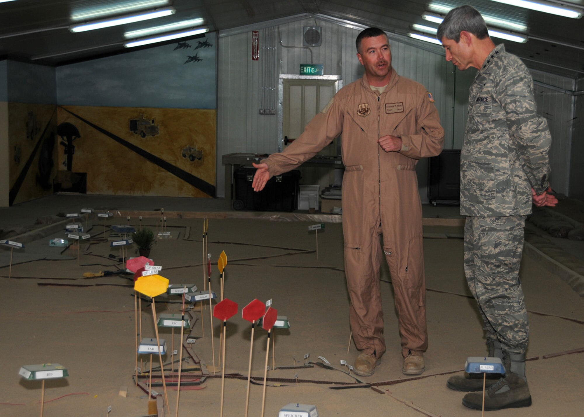 SOUTHWEST ASIA -- Tech. Sgt. Stephen Byard, 586th Expeditionary Logistics Readiness Squadron convoy commander, explains routes and threats on a sand table that the line haul truckers face during their missions to Air Force Chief of Staff Gen. Norton Schwartz at an Army base in Southwest Asia, April 7. The sand table is a realistic, scaled map of convoy routes and high threat areas throughout Iraq. Sergeant Byard is currently deployed from Andrews Air Force base, Md. and is originally from Steubenville, Ohio. (U.S. Air Force photo/ Senior Airman Courtney Richardson)