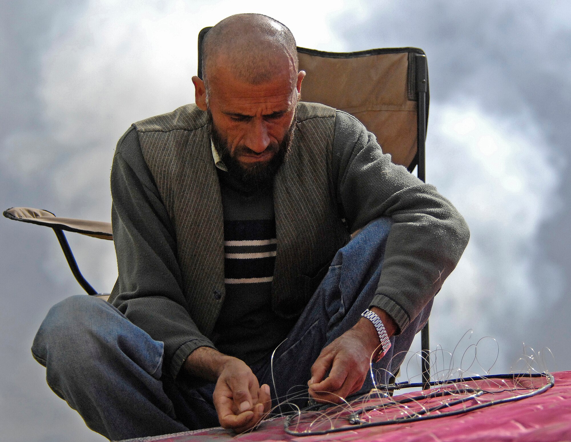 An Afghan falconer prepares a hand made snare trap for birds nesting near Bagram's burn pit area March 29. Lt. Col. Charles Wallace, 455th Air Expeditionary Wing safety chief, and his team of six safety experts hired three local falconers to help clear out areas near the flightline that were swarmed with thousands of birds. After a week of work, the falconers had caught or killed more than 250 birds surrounding the flightline and have apparently scared off most of the remaining birds over the past three weeks.
