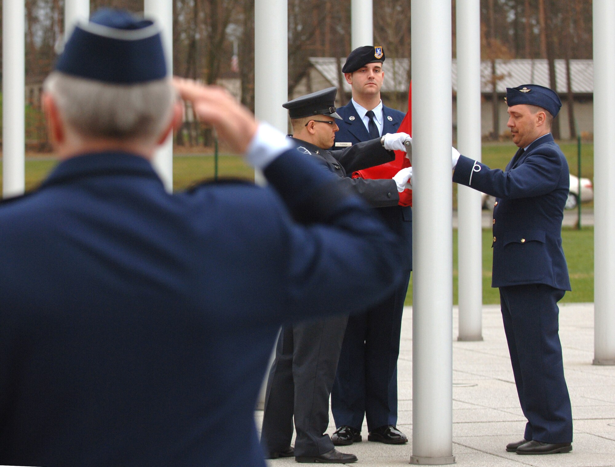 Gen. Roger A. Brady (foreground), commander of U.S. Air Forces in Europe and NATO Allied Air Component Command, salutes as (l-r) Polish Air Force Staff Sgt. Arek Sarkowski, U.S. Air Force Senior Amn. Andrew Tucker, and Belgian Air Force Adjutant Philip Van Huyck hoist the Albanian flag during an April 8, 2009, ceremony at Ramstein Air Base, Germany, to recognize the accession of Croatia and Albania as the 27th and 28th members of NATO. (Department of Defense photo by Master Sgt. Scott Wagers / Defense Media Activity-Europe)