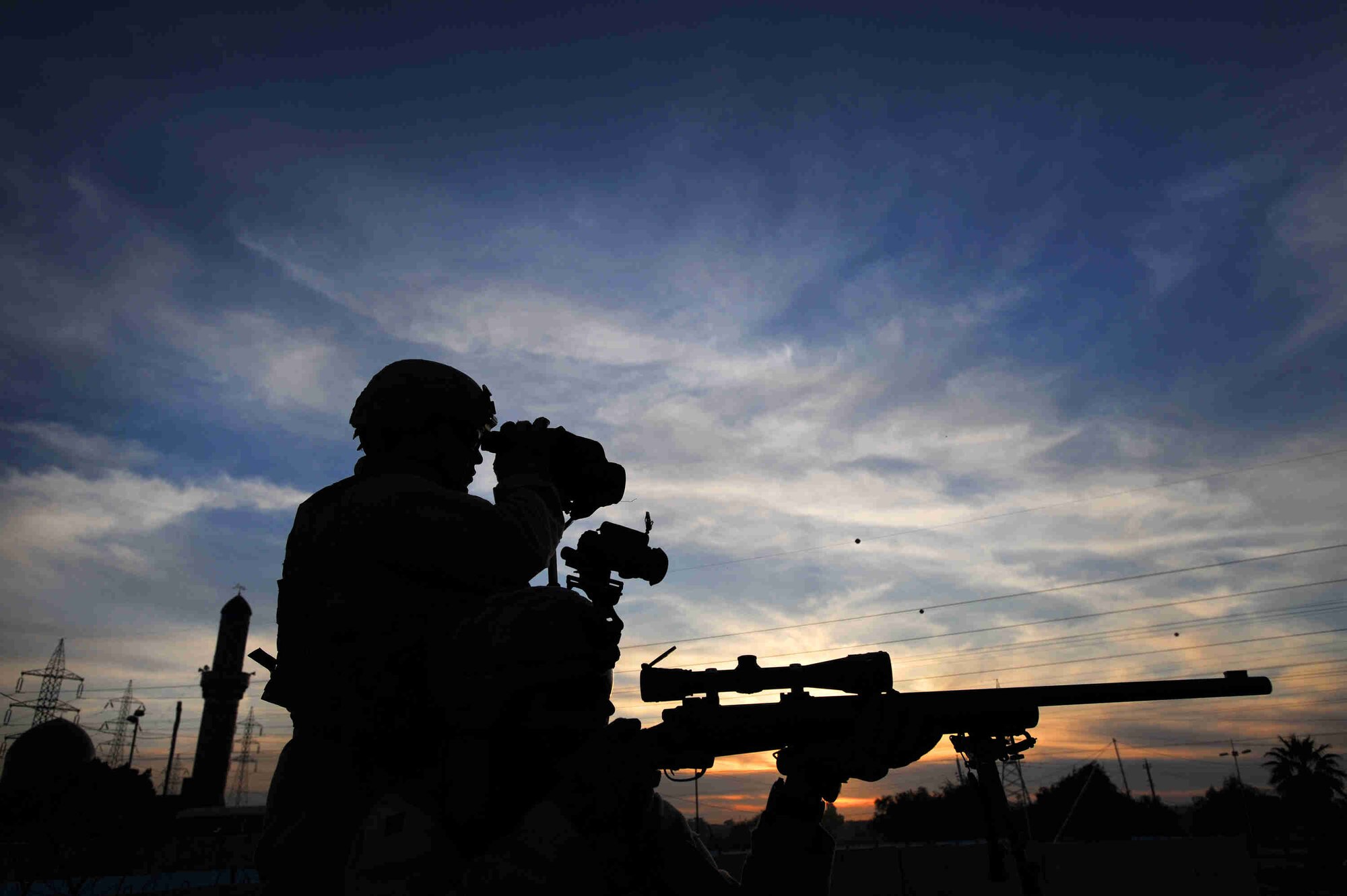 Airmen sharpshooters assigned to the Close Precision Engagement Team scan the horizon for possible threats Dec. 07, 2008 in the Doura community of southern Baghdad, Iraq. The Airmen are attached 732nd Expeditionary Security Forces Squadron, 716th Military Police Battalion. (U.S. Navy Photo by Petty Officer 2nd Class Todd Frantom)