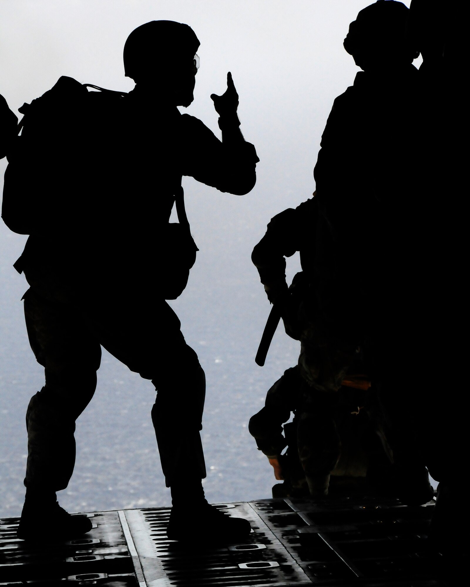 ANDERSEN AIR FORCE BASE, Guam - Jump Master, Senior Master Sgt. Paul Schaaf, signals a go for Airmen to jump during a three week jump proficiency training here April 7. The training will help them with future deployments.  (U.S. Air Force photo by Airman 1st Class Courtney Witt)
