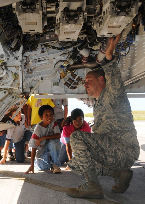 ANDERSEN AIR FORCE BASE, Guam - Senior Master Sgt. Jackey Sperling, from the 90th Expeditonary Aircraft Maintenance Unit deployed from Elmendorf Air Force Base, Alaska, shows students from Machananao Elementary School where munitions are loaded on an F-22A Raptor here, April 2.  Airmen from the 90th EAMU brought Machananao students to view the Raptors and see what a maintainer's job entails.    (U.S. Air Force photo by Staff Sgt. Jamie Lessard)
