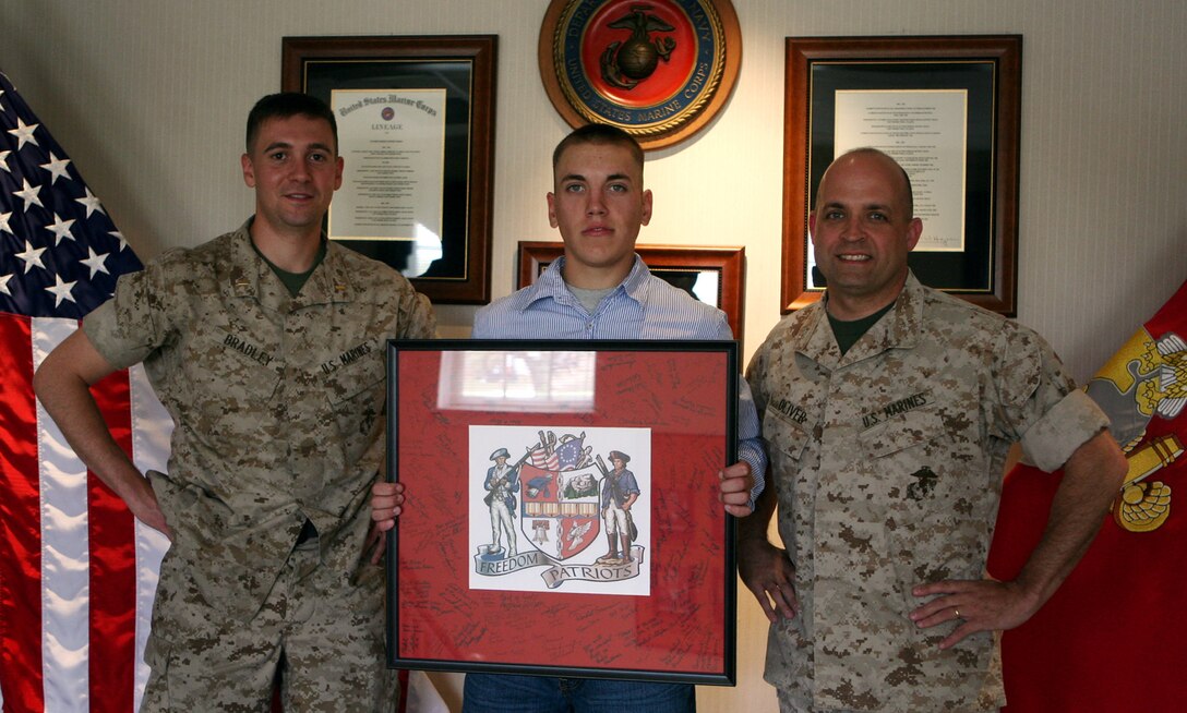 Left to right, 2nd Lt. Michael J. Bradley, Pfc. William M. Chester, and Col. Brian T. Oliver show off the emblem of Freedom High School in Morganton, N.C., at Marine Corps Base Camp Lejeune, N.C., April 7, 2009. Oliver was the principal at Freedom from July 2004 until he was activated from the reserves in January 2009. Bradley and Chester are both Freedom graduates, and all three Marines serve in 2nd Marine Logistics Group.  U.S. Marine Corps photo by Lance Cpl. Meghan J. Canla