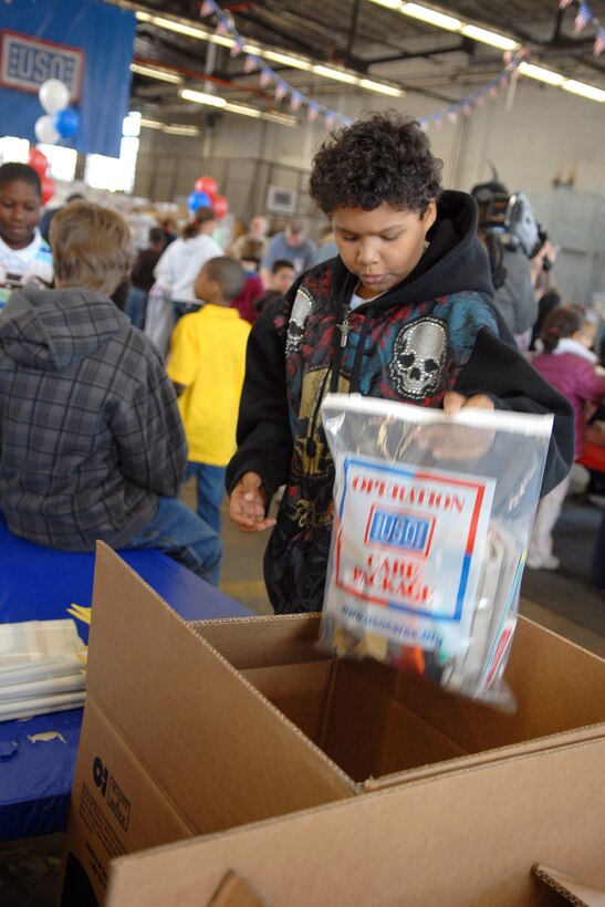 D'Andre Daniels, 10, places a USO care package into a shipping box for deployed troops April 9, 2009, at Fort Belvoir, Va. Daniels, his mother, older brother and two younger sisters volunteered part of their spring break to show their support for the military. His father is an Army paralegal stationed at Fort Belvoir. DoD photo by Army Sgt. 1st Class Michael J. Carden