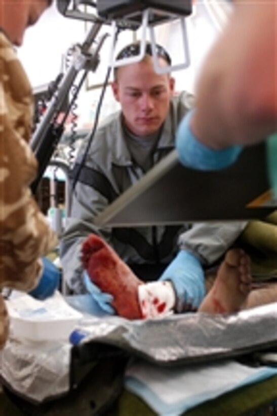 U.S. Army Sgt. Joshua Dilmore, of the 1st Battalion, 4th Infantry Regiment, U.S. Army Europe, helps medical personnel assigned to the 758th Forward Surgical Team treat a wounded Afghan security guard at Forward Operating Base Laghman, Afghanistan, on April 4, 2009.  
