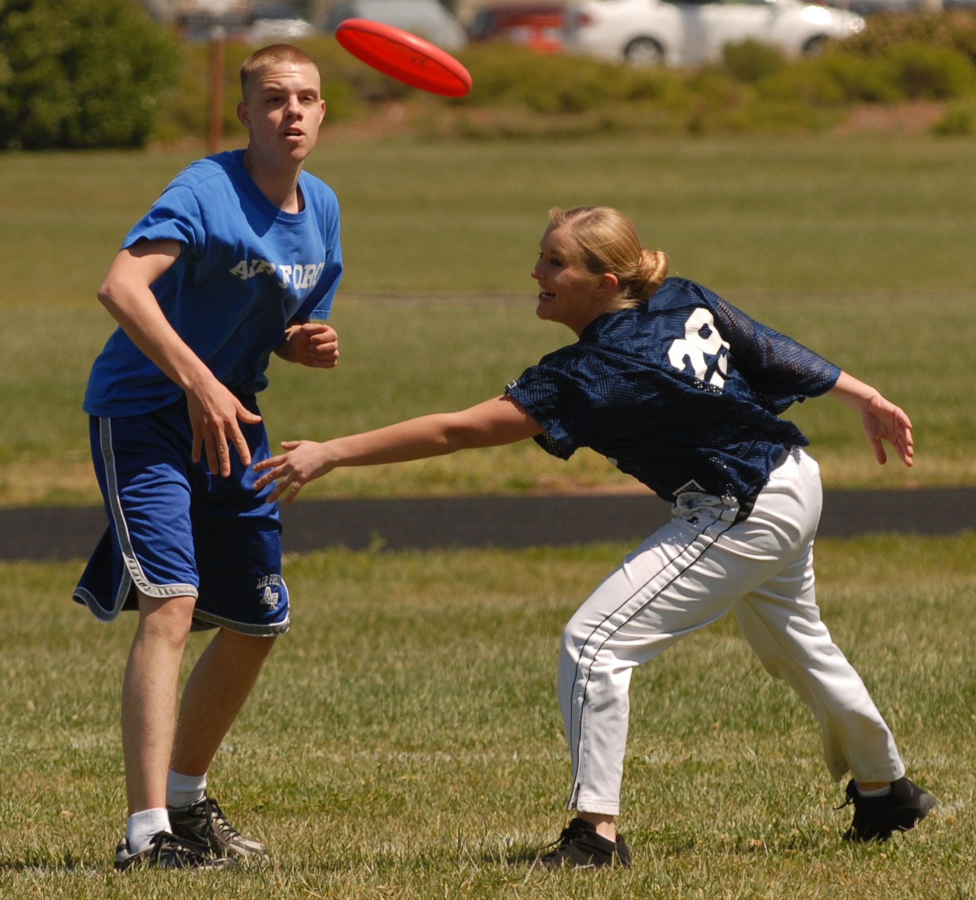 VANDENBERG AIR FORCE BASE, Calif. -- Senior Airman Morgan Cooley, a 30th Space Communications Squadron computer security manager, passes a Frisbee to a teammate during an ultimate Frisbee match held April 3 at the base track. Sports days are one of the many events used to build moral within squadrons. (U.S. Air Force photo/Airman 1st Class Antoinette Lyons)