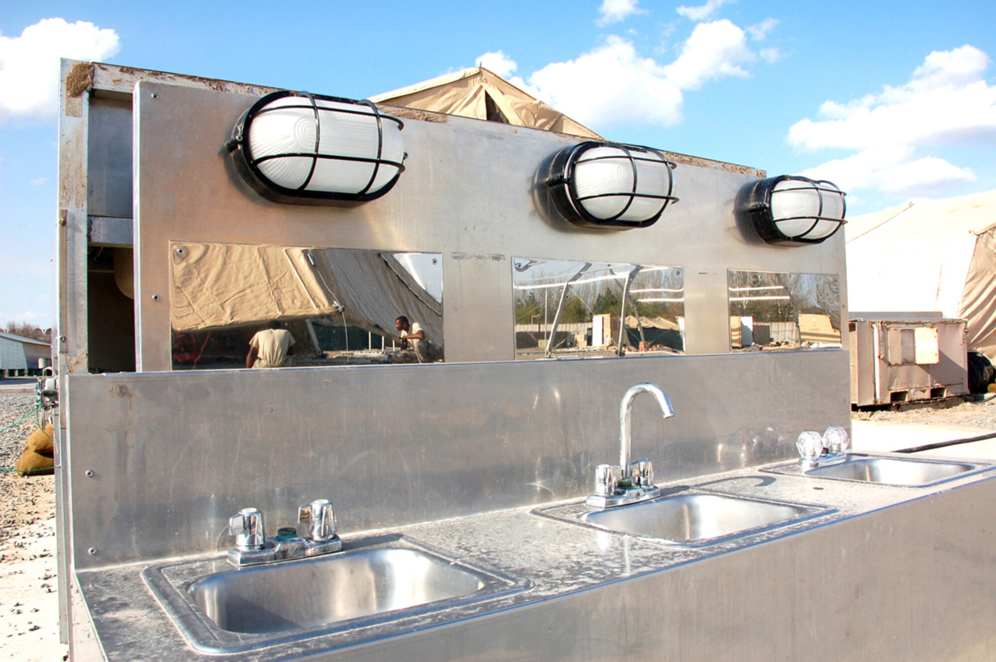 Members of a Basic Expeditionary Airfield Resources team deployed to Southwest Asia are reflected in the mirrors of a sink unit awaiting installation in new washroom facilities March 30 at Manas Air Base, Kyrgyzstan. Construction of new lodging structures is ongoing in preparations for the increased number of coalition personnel transiting through Manas to and from Afghanistan. The BEAR Airmen are deployed from Holloman Air Force Base, N.M. (U.S. Air Force photo/Tech. Sgt. Phyllis Hanson) 
