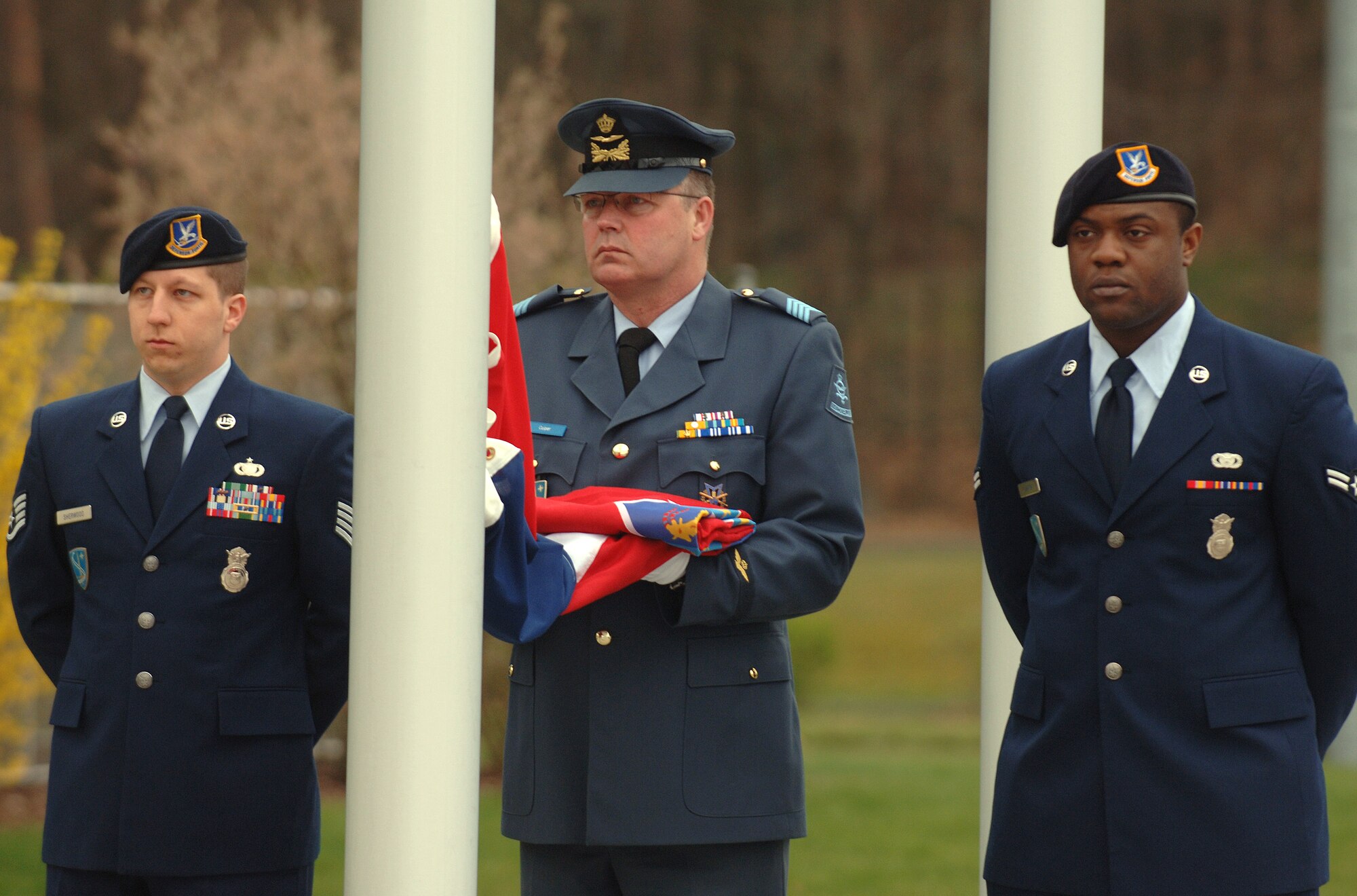 Staff Sgt. Leonard Sherwood (left) and Airman 1st Class Willie Johnson (right) join Royal Netherlands Air Force Sergeant Major Martin Cuiter to hoist the Croatian flag during a ceremony April 8 at Ramstein Air Base, Germany, marking the accession of Croatia and Albania as the 27th and 28th members of NATO. (Defense Department photo/Master Sgt. Scott Wagers)