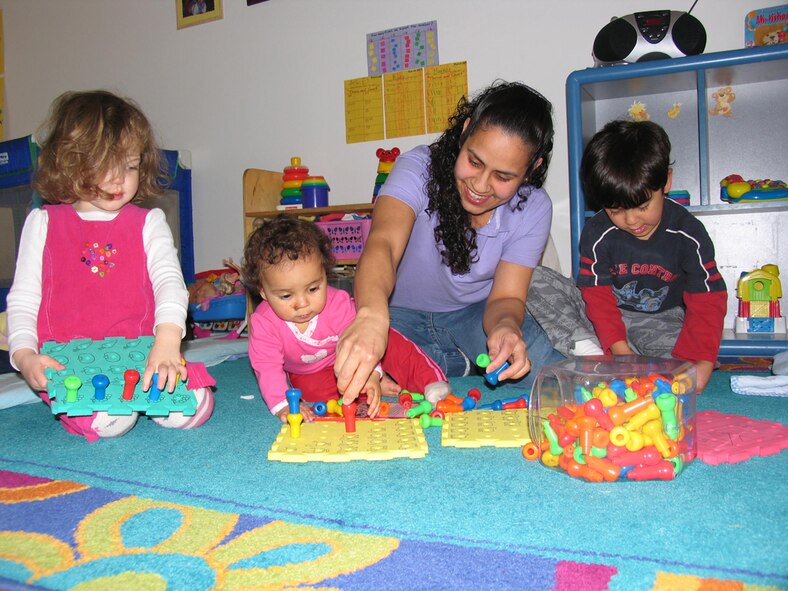 HANSCOM AIR FORCE BASE, Mass. – Leonor Ayala, who operates the Harmonious Kidz Family Child Care, is shown interacting with, from left, Ruby Donovan, Alondra Ayala-Irizarry and Leomar Ayala-Irizarry at her Hanscom Family Child Care home. Ms. Ayala is a licensed FCC Provider. For more information on becoming a Family Child Care provider call (781) 377-1695.  (U.S. Air Force photo by Rhonda Siciliano)