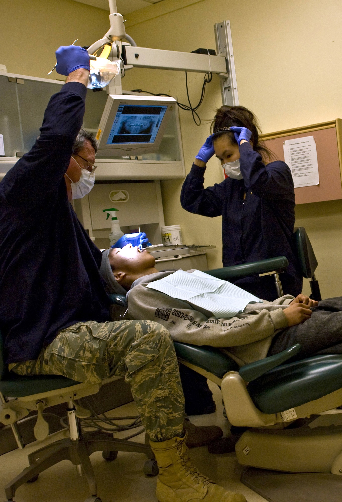 Lt. Col. (Dr.) James Clark, a dentist with the 931st Air Refueling Group, McConnell Air Force Base, Kan., and an assistant prepare a patient for a tooth removal at the Yukon-Kuskokwim Health Corporation clinic in Bethel, Alaska, on March 9, 2009. Colonel Clark performed 244 procedures in support of Operation Arctic Care, a joint military medical readiness exercise that brings no-cost health care to underserved Alaskan residents. (U.S. Air Force photo/Senior Airman Christopher Griffin)