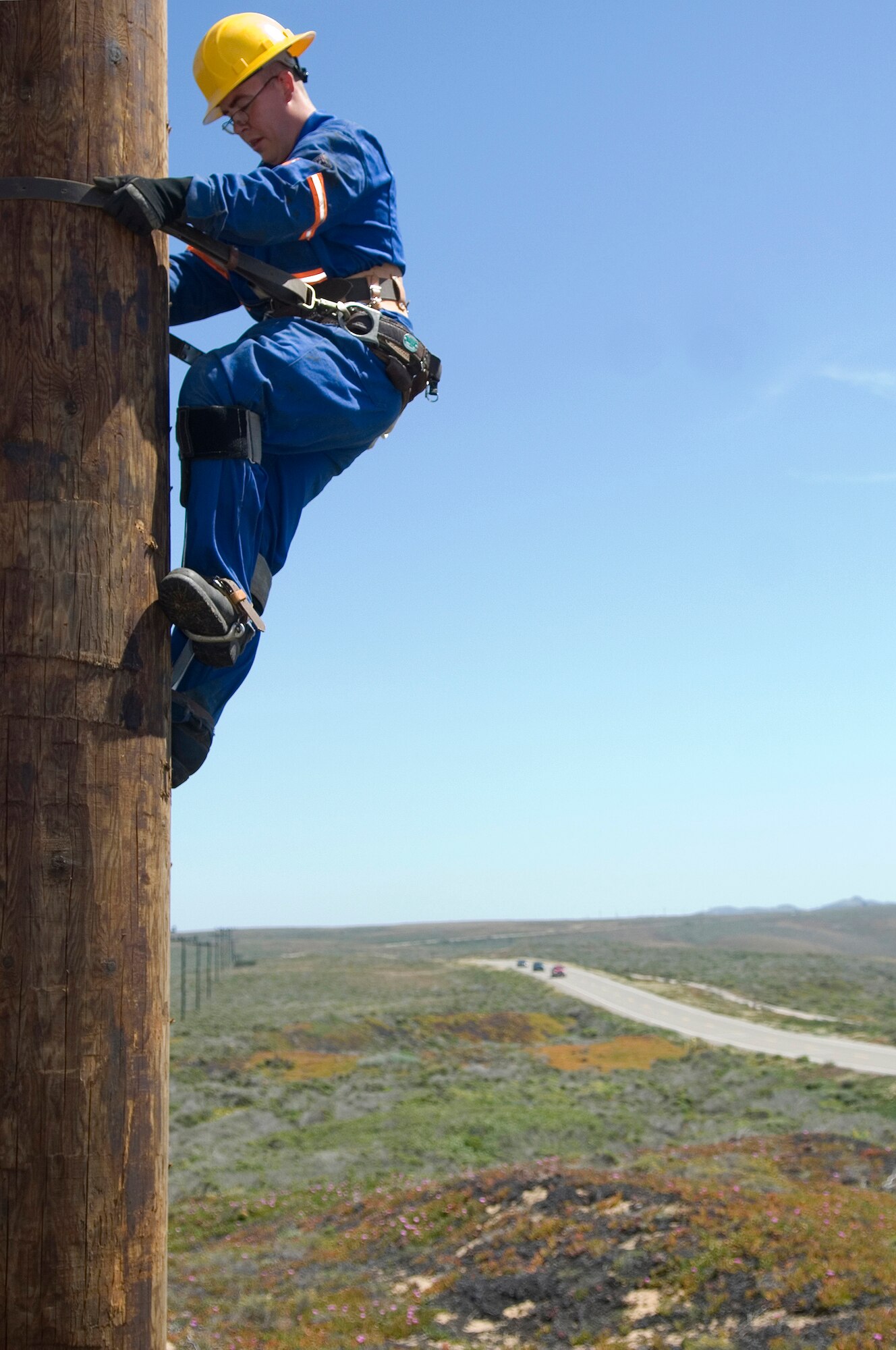 VANDENBERG AIR FORCE BASE, Calif. -- With great care, Airman 1st Class Nathanael Roberts, a 30th Civil Engineer Squadron electrician, climbs a new utility pole here to detach the rope used to install the pole. The 100-foot new utility pole is approximately 15 feet taller than the older utility pole.  The added height allows future Atlas V rockets to be transported to Space Launch Complex-3 here vertically.  (U.S. Air Force photo/Airman 1st Class Andrew Lee)