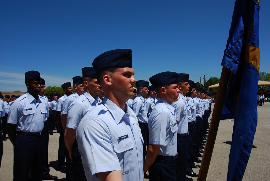Basic trainees and their Military Training Instructors during the coin ceremony and retreat held the day before formal graduation from Basic Military Training at Lackland AFB. The coin signifies the change in status from trainee to Airman. (U.S. Air Force photo/Airman Brian McGloin)