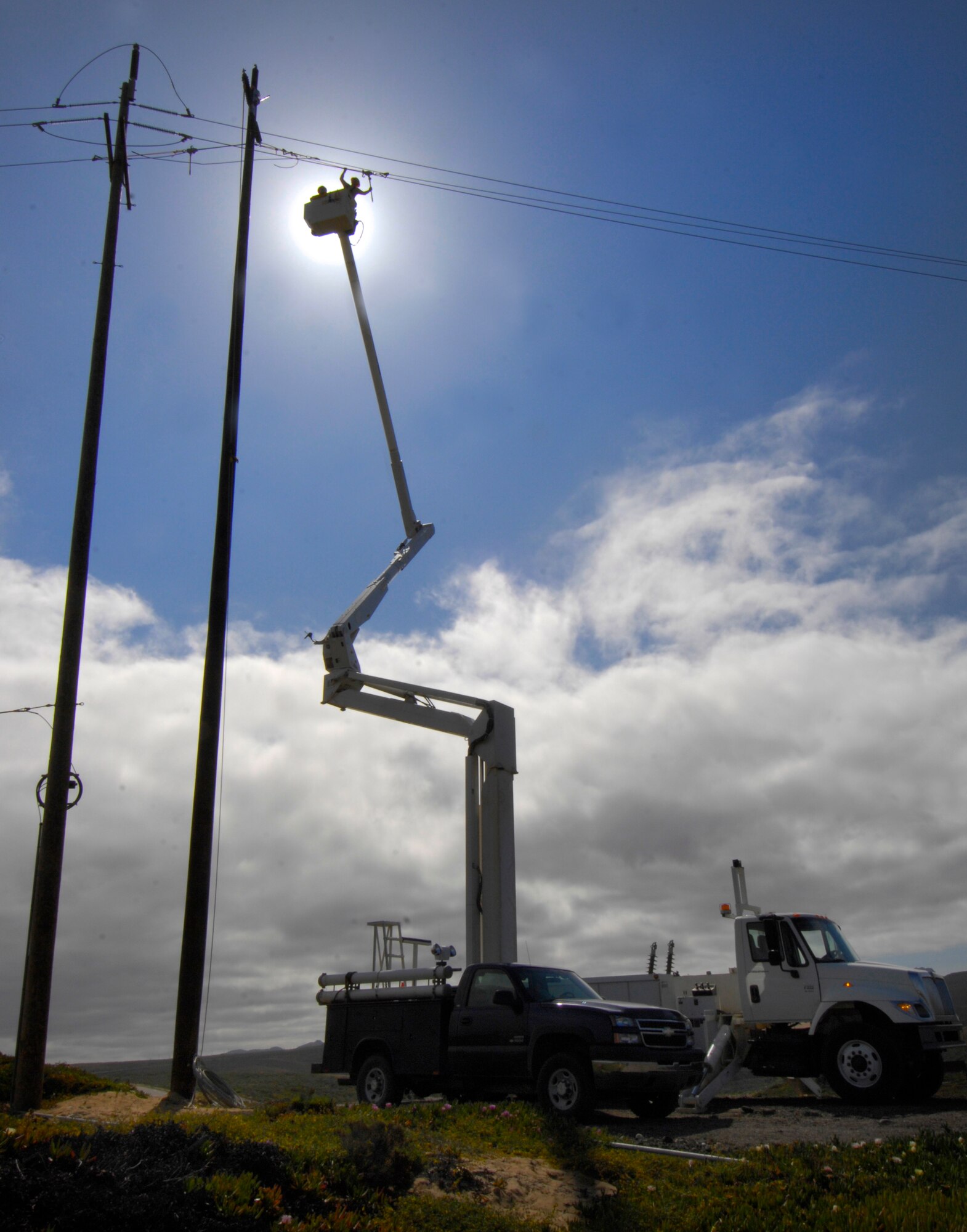 VANDENBERG AIR FORCE BASE, Calif.  -- Staff Sgt. Sean Mackey, a 30th Civil Engineer Squadron electrician, reaches out to tighten a cable here to minimize future maintenance April 9 on Vandenberg's South Base. The 100-foot new utility pole is approximately 15 feet taller than the older utility pole. The added height allows future Atlas V rockets to be transported to Space Launch Complex-3 here vertically. (U.S. Air Force photo/Airman 1st Class Andrew Lee)