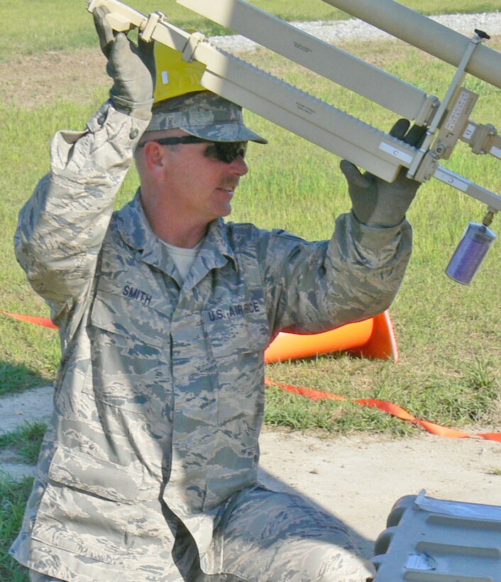 Master Sgt. Aaron Smith of the 55th Combat Communications Squadron, Robins AFB GA, holds a satellite arm steady during an operational readiness exercise.