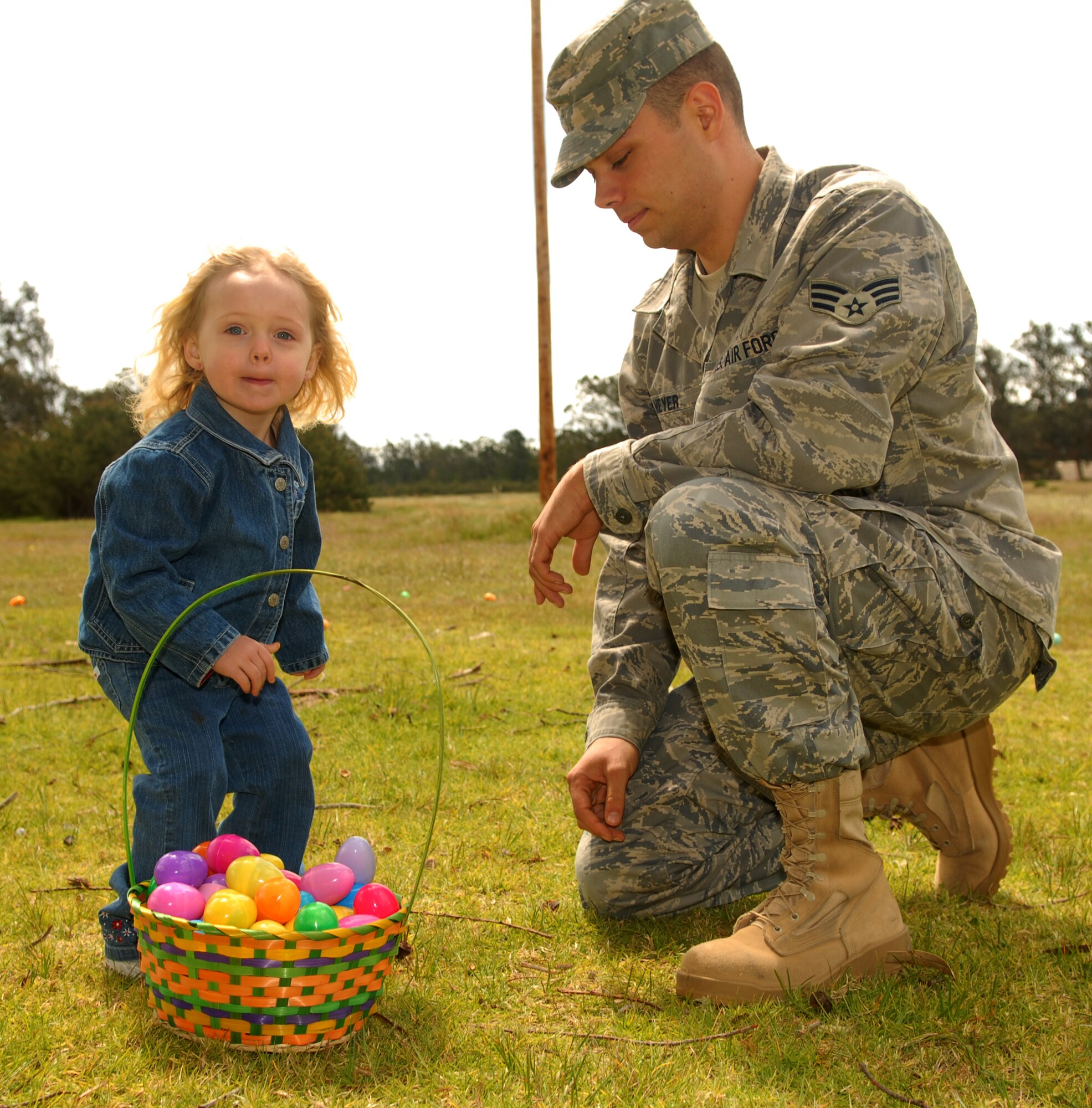 VANDENBERG AIR FORCE BASE, Calif. -- Senior Airman Matthew Meyer, a 30th Logistic Readiness Squadron computer maintainer, helps his daughter, Haley, put Easter eggs in her basket during an Easter egg hunt April 8 at Cocheo Park here. The Easter egg hunt was organized by the 30th LRS for its Airmen and their families.  (U.S. Air Force photo/Antoinette Lyons)
