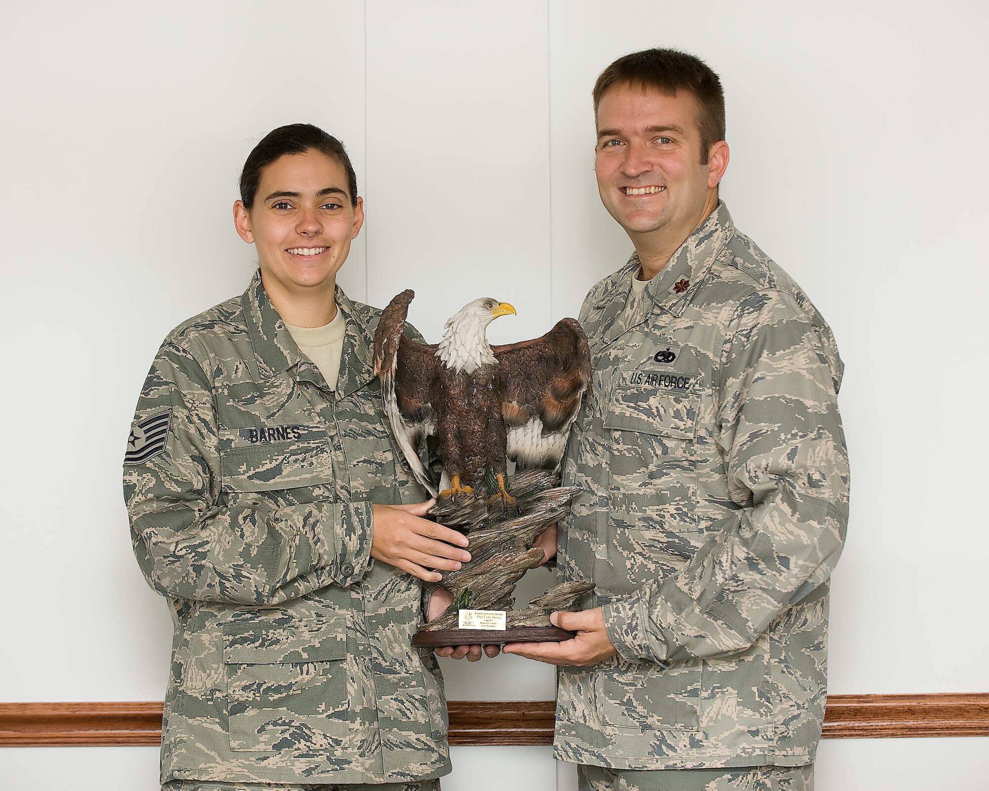 Tech. Sgt. Leslie Barnes, a senior maintenance operations center controller assigned to the 436th Maintenance Operations Squadron, displays her 1.5-foot tall John L. Levitow Award to her commander, Maj. Sean McMurray, at the 436th MOS on Dover Air Force Base, April 10. Sergeant Barnes earned top graduate honors and was awarded the award at the Class 09-3 graduation ceremony near Lackland AFB, Texas. Sergeant Barnes and eight fellow Team Dover technical sergeants graduated the Robert D. Gaylor NCO Academy, April 1. (Air Force photo by Jason Minto)
