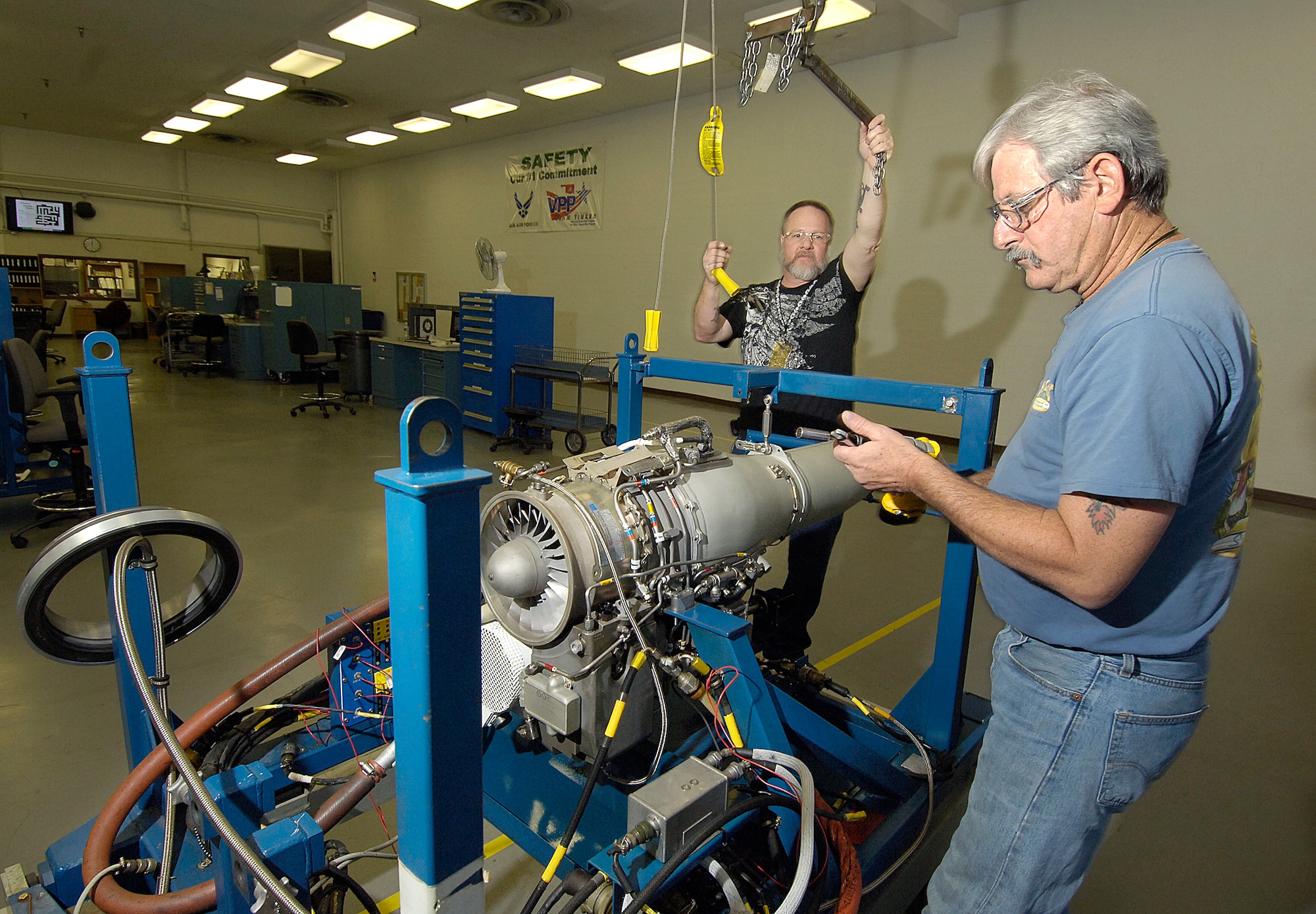 Jim McKay, front, and Mike Harris, attach an F107 engine to the test frame before rolling it into an engine test cell in Bldg. 214. The powerhouse for the Air Launched Cruise Missile gets one chance at doing its job perfectly and is overhauled at Tinker in the only shop of its kind in the world. (Air Force photos/Margo Wright) 